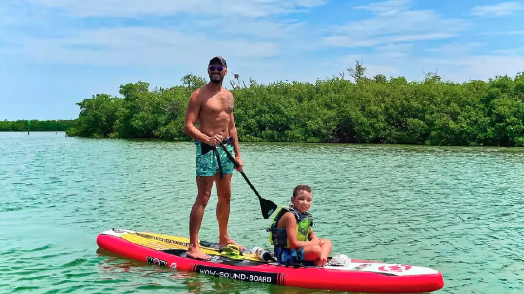 A father and son paddleboard on sanibel island