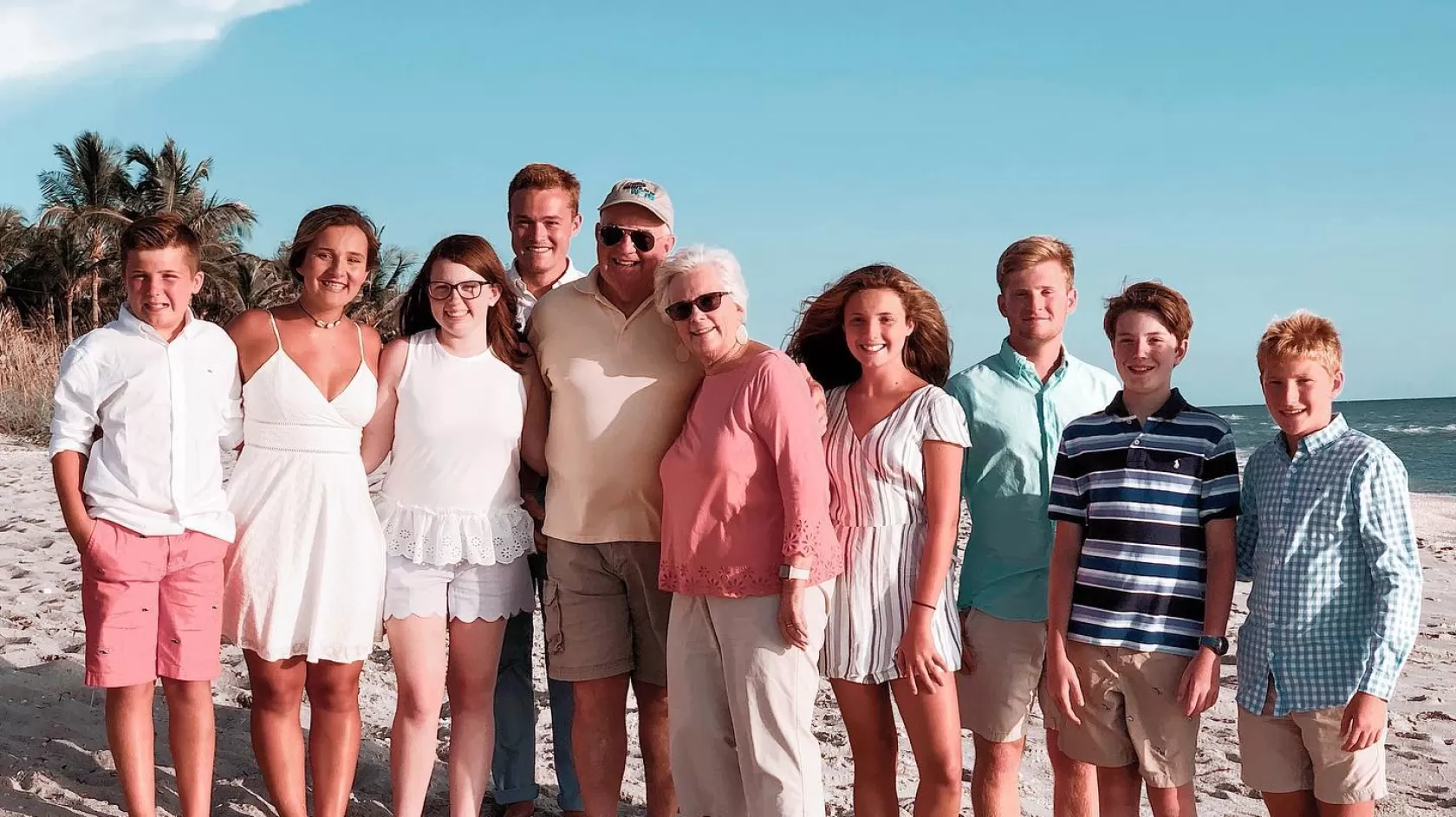 Family standing on top of a sandy beach