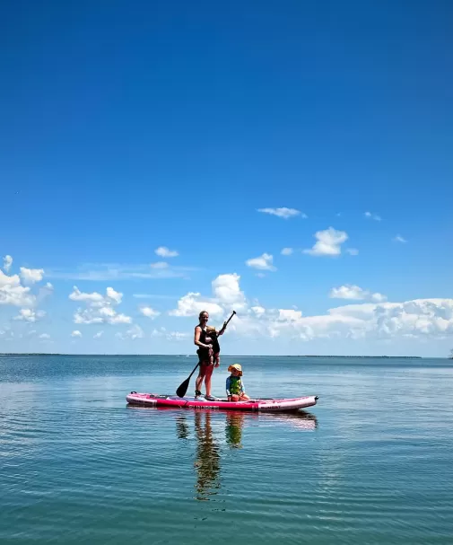 People paddleboard on calm water on Boca Grande Outer Islands.